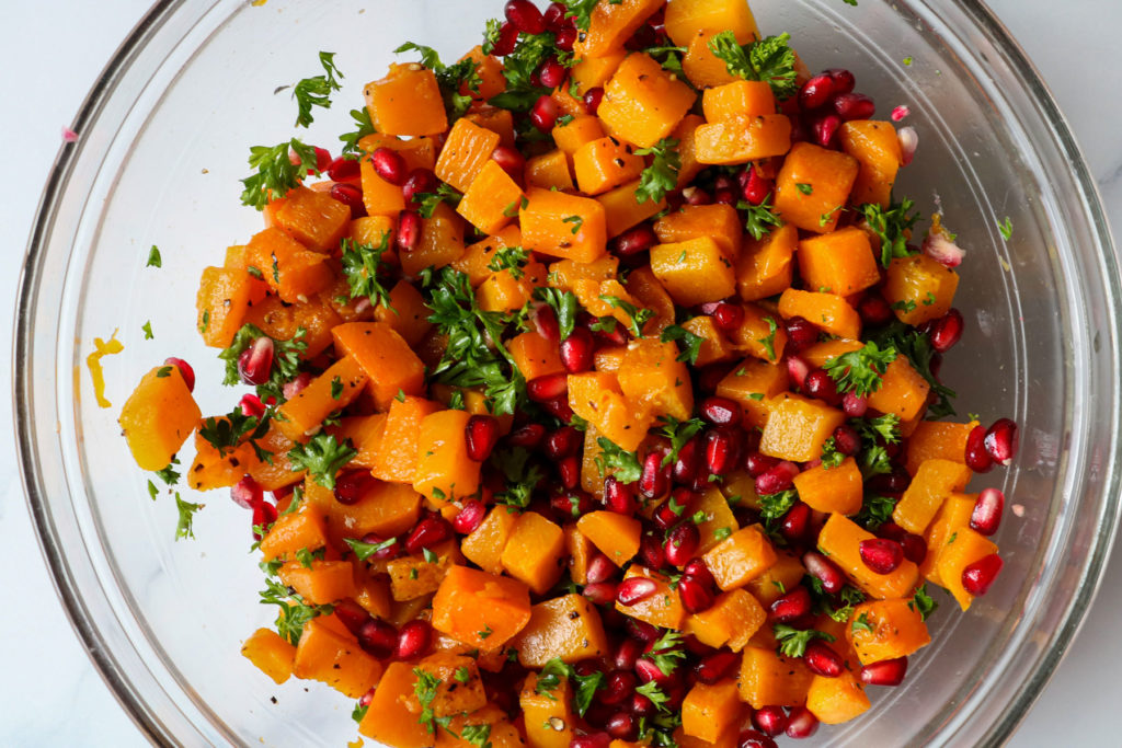 butternut squash and pomegranate with mint mixed in a bowl